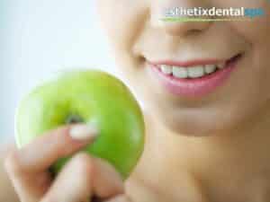 a woman eating an apple to stimulate saliva flow