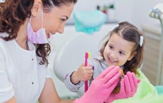 dentist helping a young girl to understand hygiene