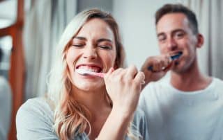 young couple brushing their teeth together