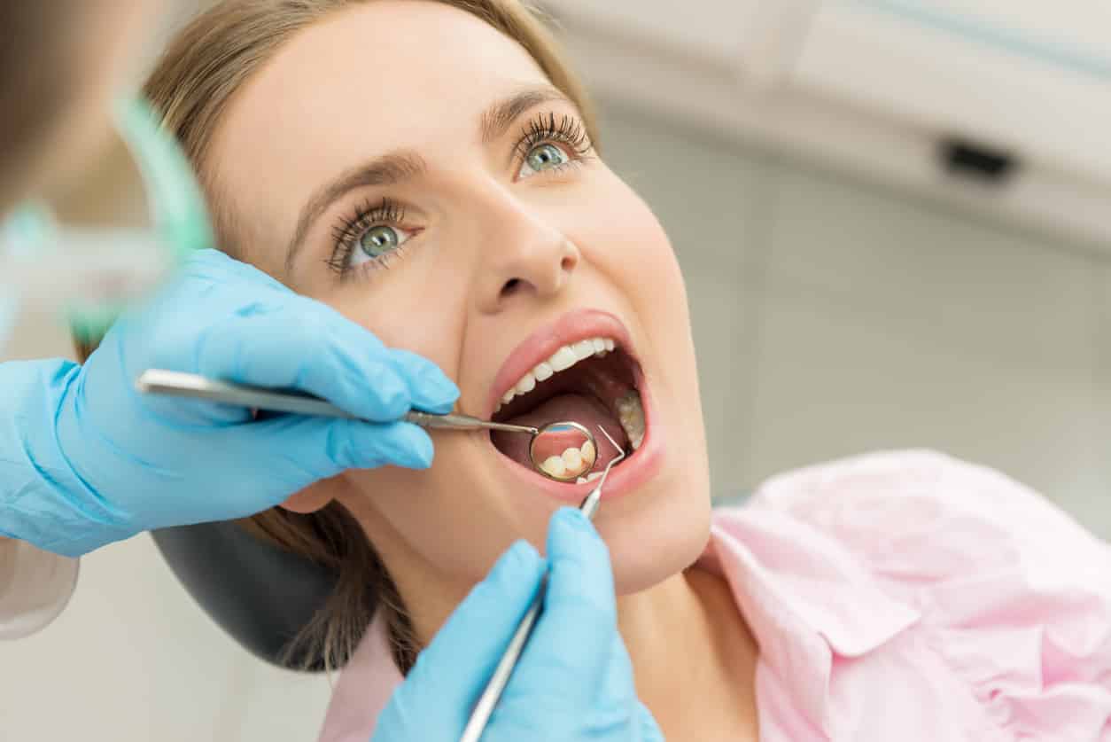 woman getting her teeth looked at to see if she will need a filling.