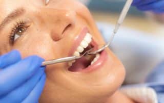 woman at the dentist getting teeth checked and fluoride treatment