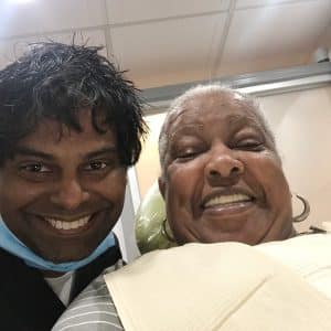Dr. Arvind Philomin Next To Happy Patient In Washington Heights Dental Office