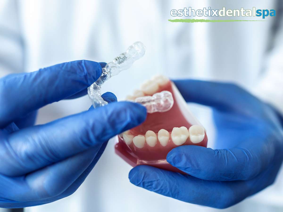 Dental professional holding an Invisalign aligner and a model of crowded teeth