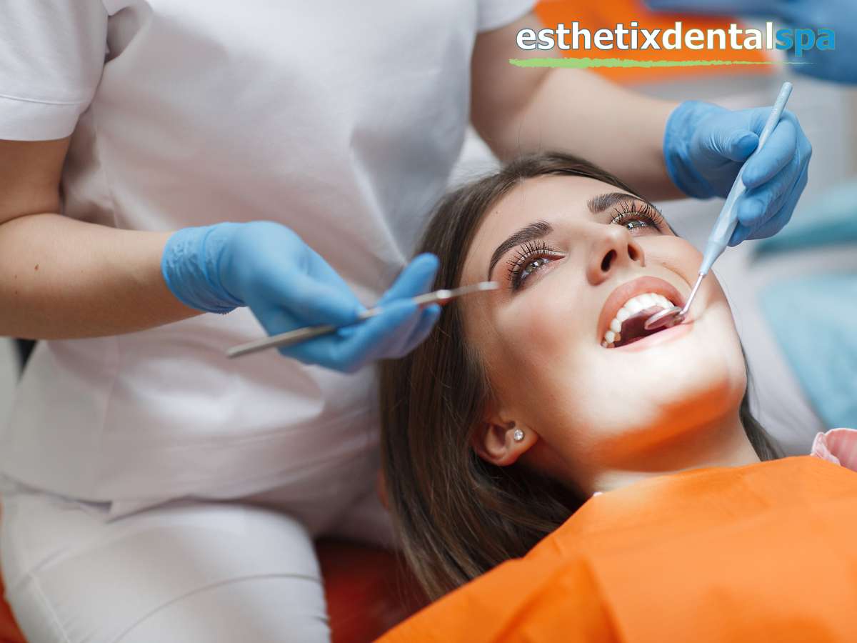 A patient in a dental chair receiving periodontal care to prevent tooth loss, with a dentist using tools to examine the teeth