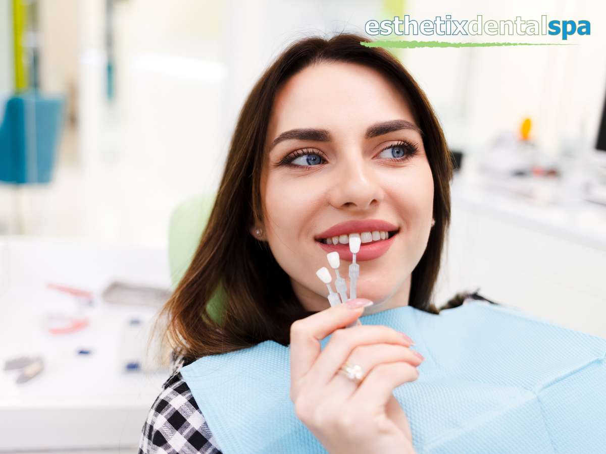 Woman comparing porcelain crowns shades at a dental clinic, reflecting a confident smile